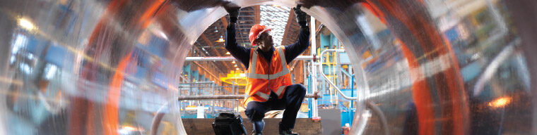 Non destructive testing operator surveying large metal pipe for quality check