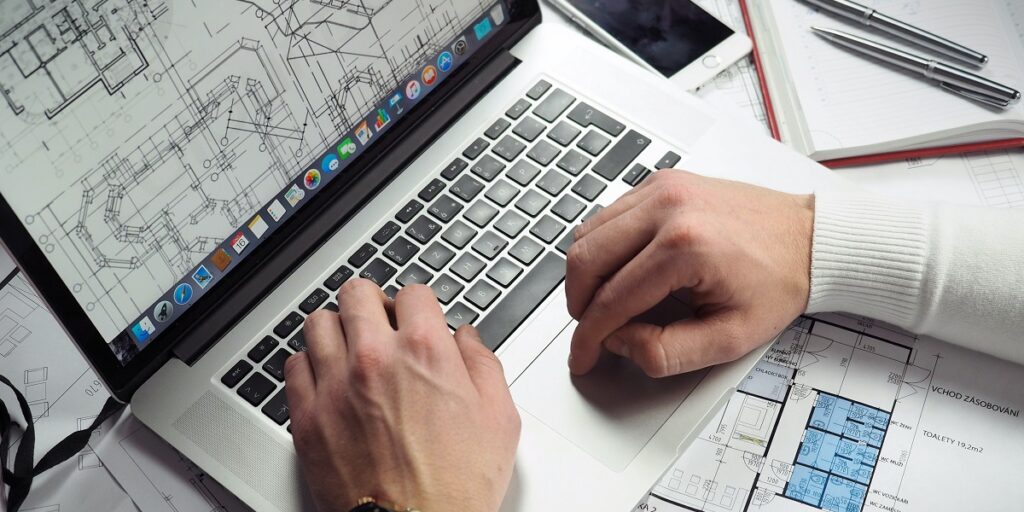 Building Services Design Engineer Apprenticeship learner looks at plans on laptop