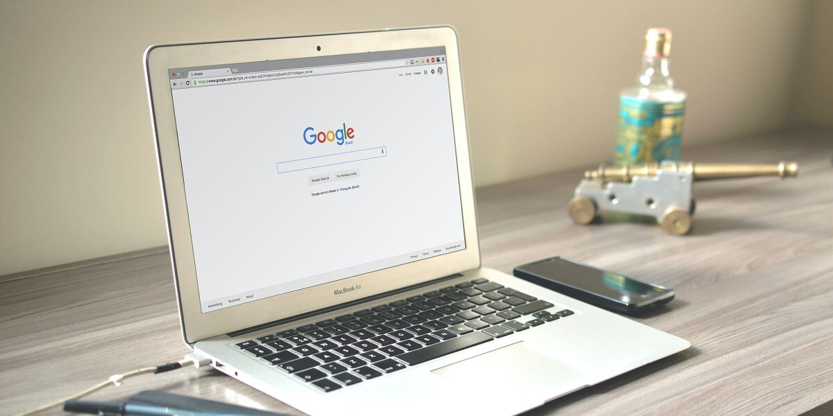 Laptop on wooden desk with Google search engine on screen