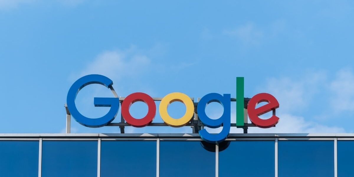 Photo of Google sign on the top of a building.