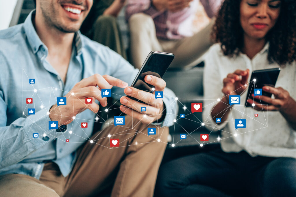 Young people sitting on stairs using smartphones for organic and paid social media