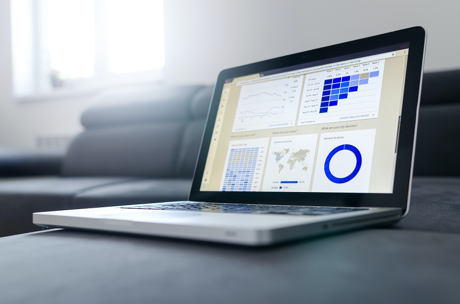 Laptop on a table with graphs and charts on the screen