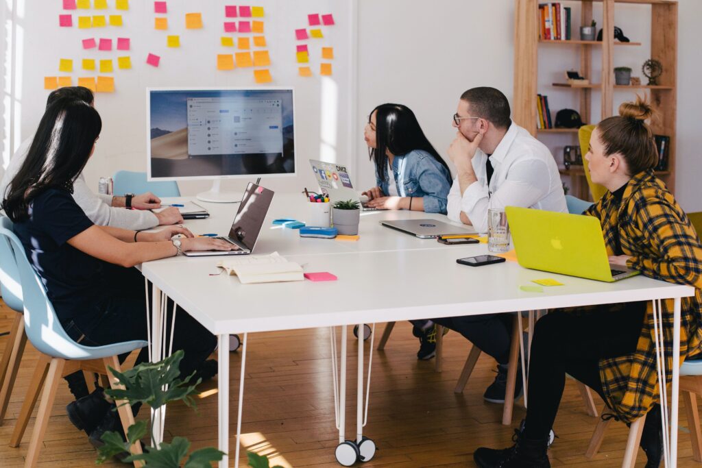 Five people in a room looking at a computer screen