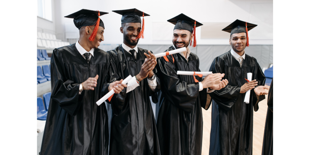 Group of four university engineer post graduates in their graduating gowns and cap with certificate 