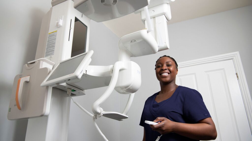 Image of a female dental nurse operating a machine.