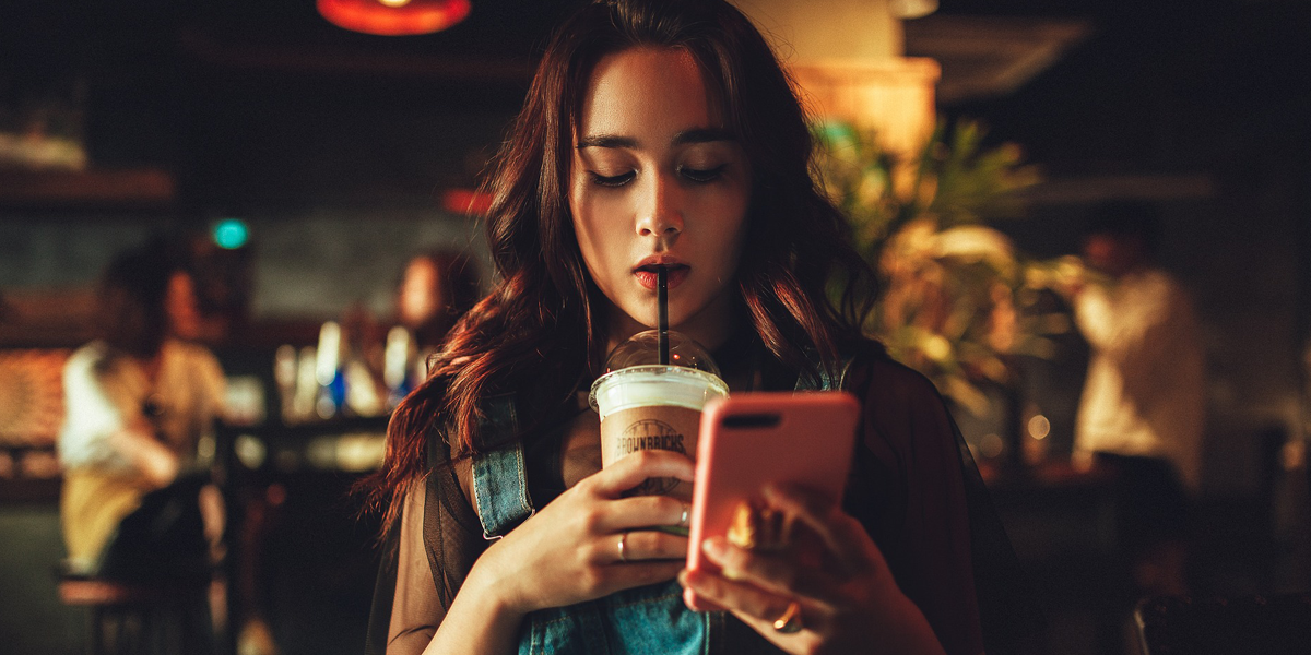 Woman browsing social media in a coffee shop