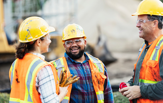 Engineering apprentices at work talking with their manager 