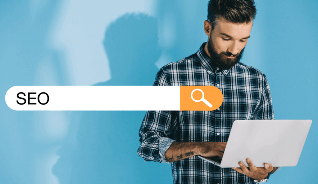 SEO techniques to boost your website's ranking  - Male standing in front of a blue wall on laptop using 
