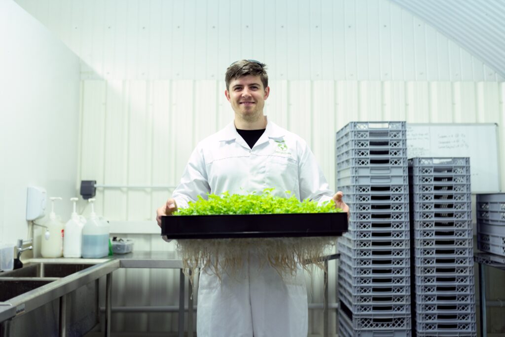 Agriculture or Horticulture apprentices will learn commercial business knowledge. image shows man in white coat with tray of plants