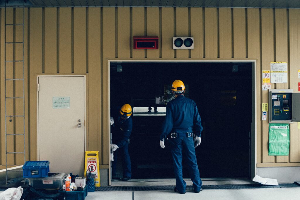 Technicians working, facing away from the camera. Image sourced from Unsplash