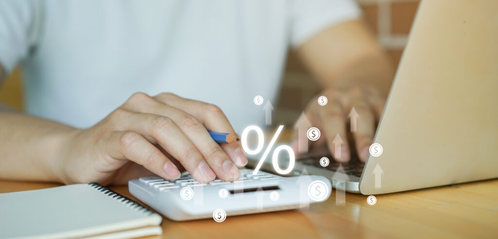 Hands working out financial calculations on a calculator.