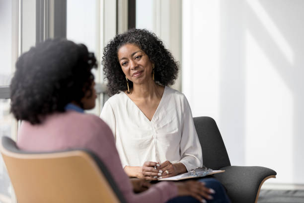Female Psychologist listens carefully to patient sat across from her