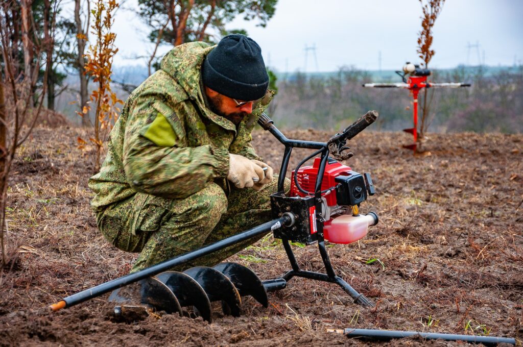 A man with a red digging tool