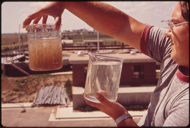 TECHNICIAN HOLDS SAMPLES OF WATER AS IT COMES TO THE PLANT (LEFT) AND WATER AFTER TREATMENT