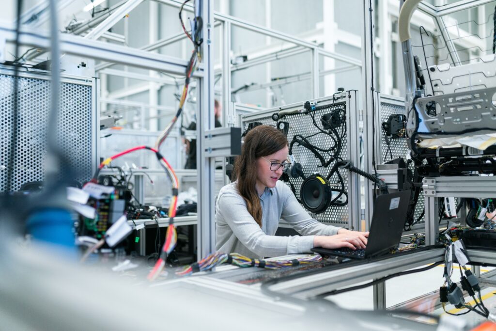 Woman working in manufacturing sat at a computer in a factory.
